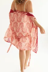 Bata de dormir corta color rosa con estampado de leopardos, con detalles de puntilla roja en el escote y en el frente.