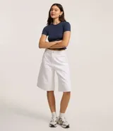 Remera de algodón ajustada al cuerpo, color marrón oscuro, con cuello redondo y ribete contrastante blanco en el cuello y los bordes de las mangas cortas.