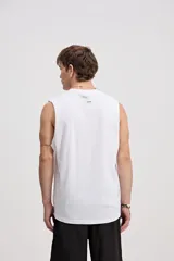 Musculosa oversize blanca de algodón, con sisas amplias y estampa frontal de inspiración tropical con palmeras y texto.