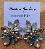 Par de caravanas con forma de flor, con pétalos de diferentes tamaños y colores: fucsia, violeta y rojo. En el centro tienen un cristal facetado y pequeños strass blancos.