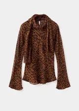 Blusa de manga larga acampanada con estampado de leopardo, cuello redondo y detalle de fular integrado en el cuello.