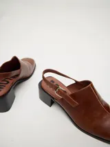 Zuecos clásicos color beige, hechos 100% en cuero vacuno wax y charol, con taco de madera de 5cm de altura y correa trasera ajustable.