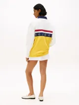 Chomba de rugby Tommy Hilfiger Sailing, unisex, de corte amplio y hombros caídos. Diseño color block blanco, amarillo y azul, con logo de la marca bordado en el pecho.