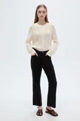 Pantalón jean negro de tiro medio y corte flare, con bolsillos laterales y traseros.
