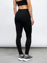 Calza deportiva Umbro modelo Legging Bink para mujer, de color negro, con cintura alta cruzada y elástica con la marca estampada.