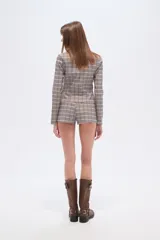 Short de viscosa a cuadros en tonos blanco, negro y bordó, con bolsillos laterales y calce medio ajustado al cuerpo.