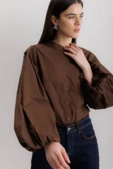 Camisa color borgoña de algodón con elastano, cuello mao y mangas largas abullonadas.