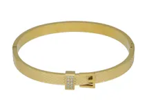 Esclava rígida de acero con baño de oro, con textura grabada y detalle de hebilla decorativa con incrustaciones de circonias.