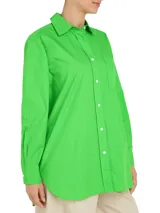 Camisa verde de popelín de algodón orgánico, corte oversize con hombros caídos, cuello inglés, bolsillo de parche en el pecho y logo bordado en la manga.