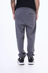 Pantalón deportivo de felpa color negro, con cintura elástica ajustable mediante cordón, puños elásticos en los tobillos y bolsillos laterales.