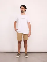 Remera blanca de manga corta con cuello redondo y un pequeño logo estampado en el pecho.