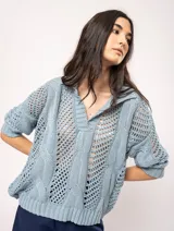 Sweater tejido de algodón color crudo, con cuello polo y escote en V. Diseño con ochos verticales en delantera, espalda y mangas, y punto abierto.