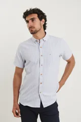 Camisa de manga corta a rayas verticales blancas y celestes, con cuello abotonado y bolsillo en el pecho.