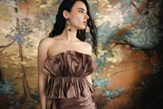 Top strapless de tafeta azul con leve brillo, con diseño estructurado de volados y frunces en el escote y la cintura.