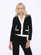 Conjunto de dos piezas compuesto por un saco entallado de manga larga con cierre frontal de botones y solapas en contraste blanco, y un pantalón de corte recto y tiro alto.