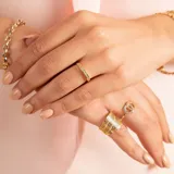 Anillo tipo alianza de oro amarillo 18k con engaste de circonias en la mitad de su circunferencia.