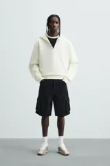 Bermuda de denim de algodón, color celeste lavado, de corte relajado (relaxed fit). Presenta cinco bolsillos, incluyendo bolsillos cargo plastrón con solapa en las perneras.