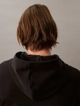 Buzo con capucha de Calvin Klein confeccionado en tejido de felpa de algodón. Presenta un diseño de corte relajado con bolsillo tipo canguro, puños y dobladillo acanalados, y el logo de la marca estampado en el frente.