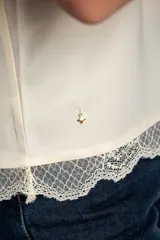 Blusa satinada marrón con detalles de encaje en el escote en V y en el ruedo. Presenta tirantes finos regulables.