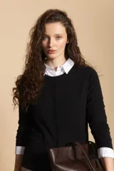 Cardigan negro de tejido suave y liviano, con cierre frontal abotonado y cuello redondo.