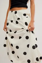 Falda midi de corte A y cintura baja, confeccionada en popelina de algodón color marrón terracota con estampado de lunares celestes.