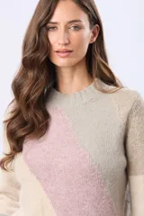 Buzo tejido de punto con diseño de franjas diagonales en tonos rosado, beige y gris, cuello redondo y manga larga.