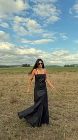 Vestido largo de corte sirena con diseño geométrico de rombos en colores violeta y naranja. Presenta breteles finos, escote recto y una falda con caída fluida que termina en una pequeña cola.