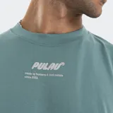 Remera de algodón con corte oversize, color verde azulado, con cuello redondo y estampado frontal en relieve con logo de la marca.