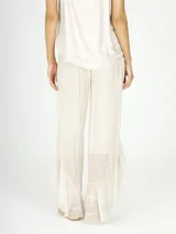 Pantalón palazzo color crema, de seda con volados en el ruedo.