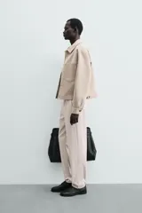 Pantalón chino de corte regular fit, confeccionado en tejido de algodón con elasticidad. Presenta bolsillos frontales, bolsillos traseros de vivo y cierre frontal con cremallera y botón.