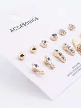 Set de seis pares de caravanas doradas con diversos diseños, incluyendo esferas lisas, cristales individuales, flores con strass, gotas con cristal, barras con strass y triángulos con flecos de cadena.