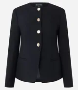 Blazer de sastrería estructurado en tejido crepe, con cuello redondo, cierre frontal con botones metálicos, bolsillos embutidos y mangas largas. Presenta un corte entallado que define la silueta.