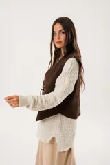 Chaleco marrón de gamuza con cordones laterales y tachas plateadas.