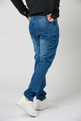 Pantalón jean clásico para hombre en color azul con efecto lavado y costuras en contraste.