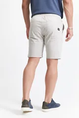 Bermuda de gabardina color beige, con diseño de cinco bolsillos, cintura con elástico y cordón ajustable.