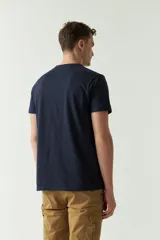 Remera color arena con estampado de edificio antiguo y texto en negro.