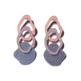 Aros colgantes con tres figuras geométricas irregulares de acrílico en tonos rosa, lila y gris con glitter.