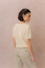 Sweater tejido celeste de manga corta con textura y delicadas líneas horizontales en relieve. Presenta cuello redondo y calce amplio con hombros caídos.