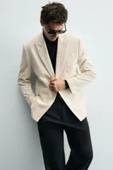 Blazer de corte regular confeccionada en pana con mezcla de algodón. Presenta cuello con solapas de pico, cierre frontal de botonadura cruzada, bolsillo de vivo en el pecho y bolsillos con solapa en la cadera.