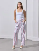 Pantalón de lino blanco con rayas verticales rosadas y celestes, de corte recto y tiro alto. Tiene pretina ancha elastizada con lazo de ajuste y bolsillos inclinados en la parte delantera.