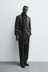 Blazer de corte regular confeccionada en pana de algodón, con diseño de botonadura cruzada. Presenta cuello con solapas de pico, manga larga con puños abotonados, bolsillos con solapa en la cadera y abertura central en la espalda.