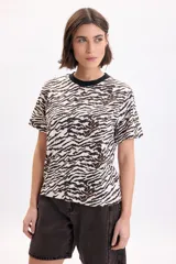 Remera de manga corta con estampa animal print en tonos beige, tostado y negro, cuello redondo negro y corte recto.