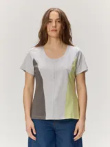 Remera de manga corta con escote redondo y diseño de paneles verticales en colores gris, marrón y verde lima, con costuras centrales decorativas.