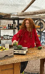 Buzo tejido a mano en lana merino, de corte oversized y diseño en bloques. Presenta un vibrante color rojo con detalles bordados a mano en forma de flores y texturas en relieve.