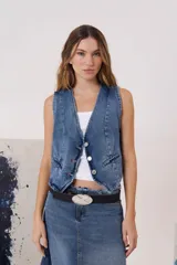Chaleco de denim con escote en V y cierre frontal de botones metálicos. Presenta bolsillos delanteros simulados y un corte entallado.