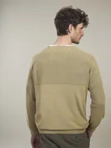 Sweater de algodón con cuello redondo, diseño de tejido combinado con textura acanalada en la parte superior y bolsillo frontal pequeño con etiqueta decorativa.