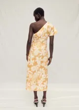Vestido midi de lino con estampado floral en tonos amarillos y blancos. Presenta un diseño asimétrico con un solo hombro, cintura drapeada y una abertura lateral en el bajo.