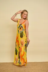 Vestido largo de gasa de seda con estampado floral en tonos amarillos, naranjas y verdes, sin mangas y corte al bies con caída fluida.