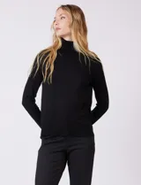 Polera de tejido fino, color rosado, con cuello alto, manga larga y detalle de tajo en los puños.