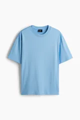 Remera de algodón color celeste, con cuello redondo, mangas cortas y hombros caídos de corte relajado.
